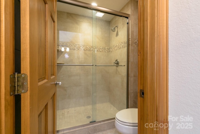 140 Slickrock Rd Unit F3, Burnsville, NC 28714 - bathroom featuring toilet, tile patterned flooring, a shower stall, and a textured wall