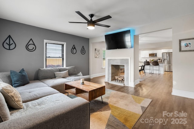 2212 Acme Rd, Belmont, NC 28012 - living room featuring ceiling fan, light wood-type flooring, baseboards, and a fireplace