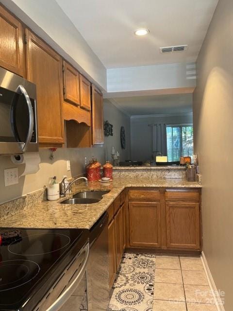 303 Heritage Pkwy, Fort Mill, SC 29715 - kitchen featuring appliances with stainless steel finishes, a sink, light tile patterned floors, and brown cabinets