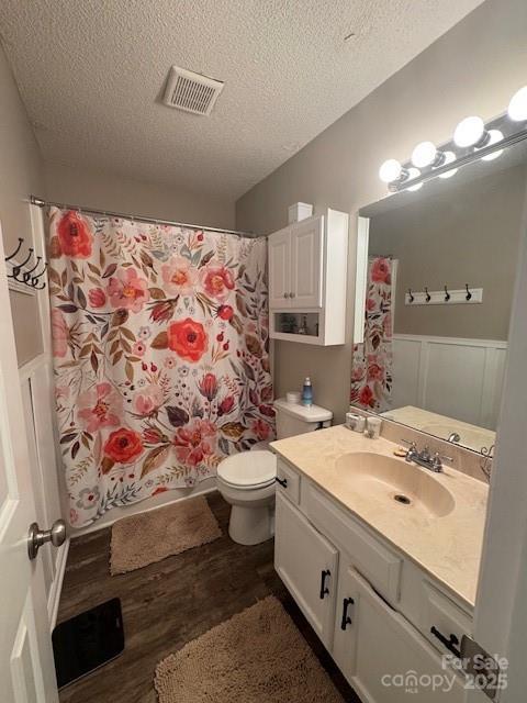 303 Heritage Pkwy, Fort Mill, SC 29715 - full bathroom with a textured ceiling, wood finished floors, wainscoting, vanity, and toilet