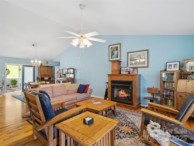 17 Gun Flint Dr, Burnsville, NC 28714 - living area featuring vaulted ceiling, a chandelier, light wood-style floors, a glass covered fireplace, and ceiling fan