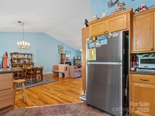 17 Gun Flint Dr, Burnsville, NC 28714 - kitchen featuring freestanding refrigerator, vaulted ceiling, dark countertops, a chandelier, and hanging light fixtures