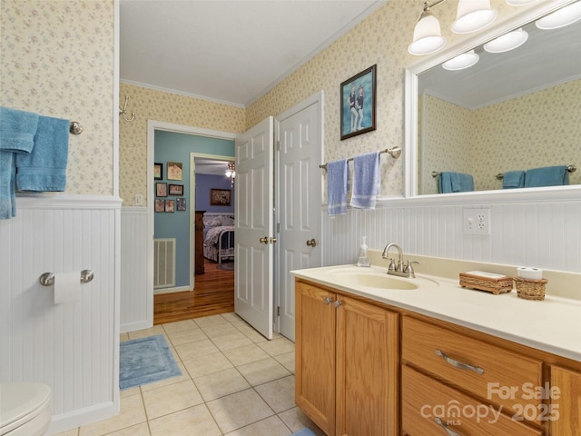 17 Gun Flint Dr, Burnsville, NC 28714 - bathroom with ornamental molding, tile patterned floors, vanity, wainscoting, and toilet