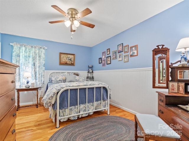 17 Gun Flint Dr, Burnsville, NC 28714 - bedroom with wainscoting, wood finished floors, and a ceiling fan