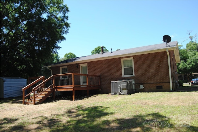 back of house with a deck, brick siding, crawl space, cooling unit, and a lawn