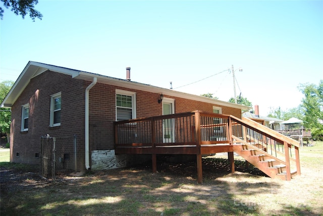 rear view of house with a deck, stairway, and brick siding