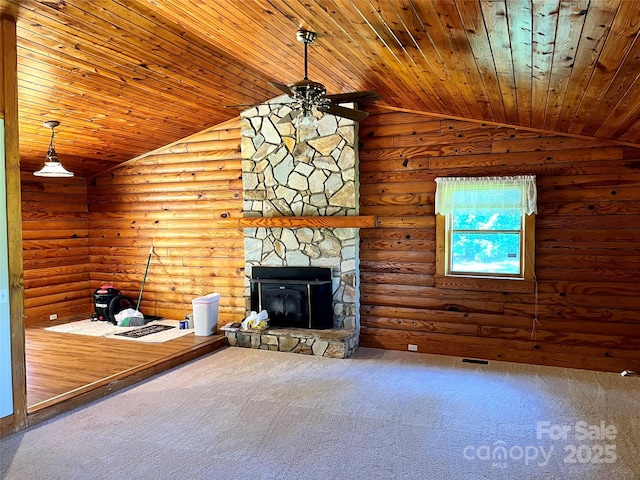 carpeted living room featuring vaulted ceiling, a ceiling fan, wood ceiling, a stone fireplace, and log walls