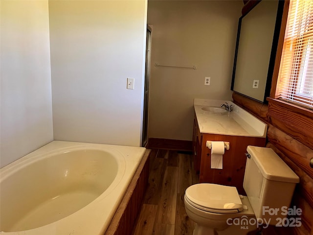 full bathroom with wood finished floors, toilet, a garden tub, and vanity