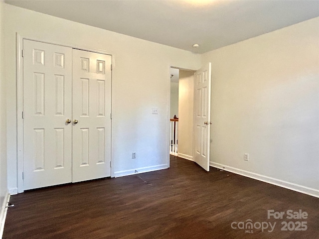 9907 Furlong Trl, Charlotte, NC 28269 - unfurnished bedroom with dark wood-type flooring, baseboards, and a closet