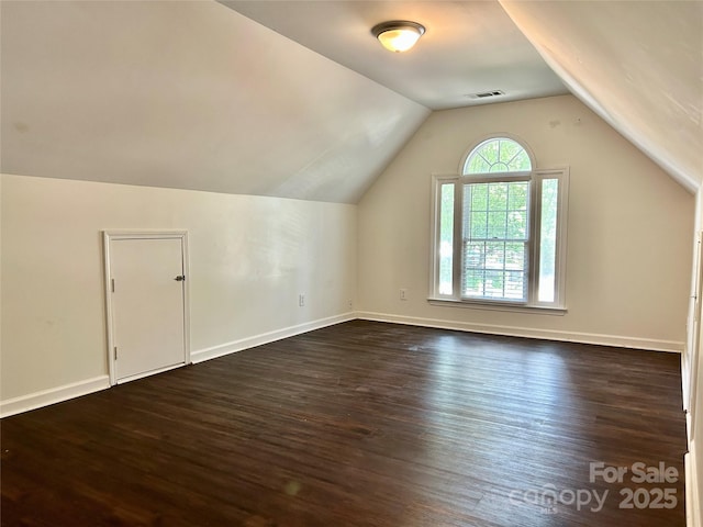 9907 Furlong Trl, Charlotte, NC 28269 - additional living space with dark wood-style floors, vaulted ceiling, and baseboards