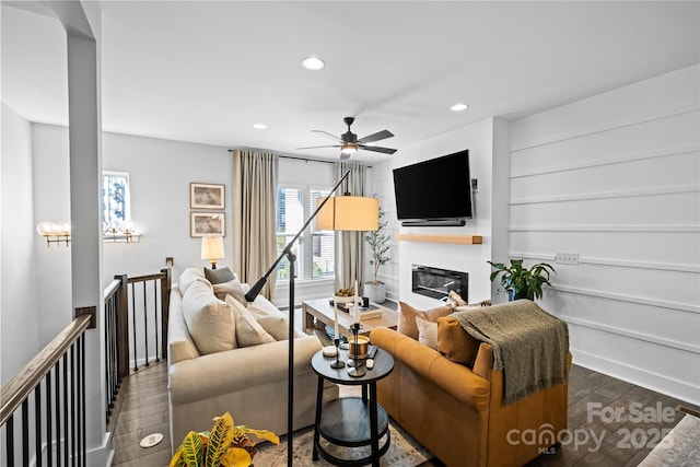 living area featuring wood finished floors, recessed lighting, a ceiling fan, baseboards, and a glass covered fireplace