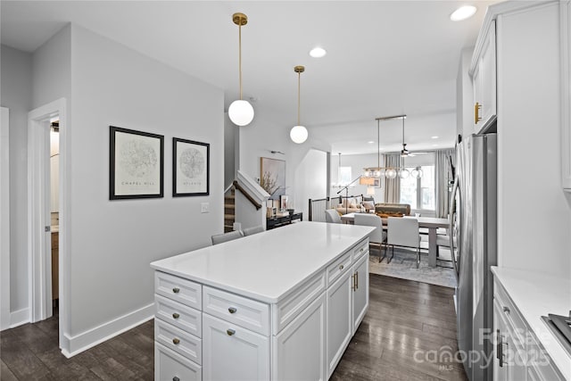 kitchen with freestanding refrigerator, dark wood finished floors, light countertops, white cabinetry, and recessed lighting