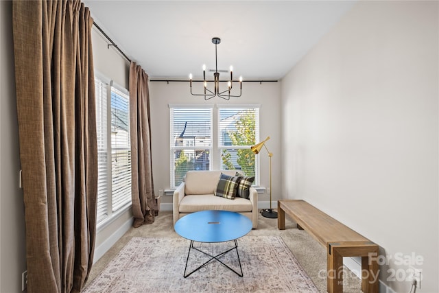 sitting room featuring a chandelier, carpet flooring, and baseboards