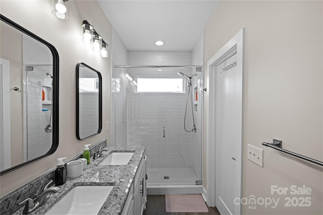 bathroom featuring a shower stall and double vanity