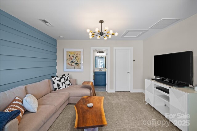 living room with light colored carpet, a chandelier, and baseboards