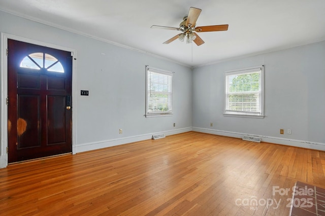 entrance foyer with ceiling fan, ornamental molding, light wood finished floors, and visible vents