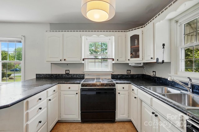 kitchen with black range with electric cooktop, dark countertops, white cabinets, and a sink