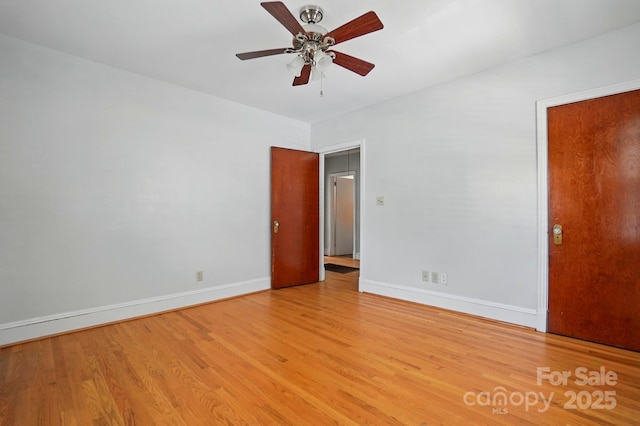 spare room with ceiling fan, baseboards, and light wood finished floors