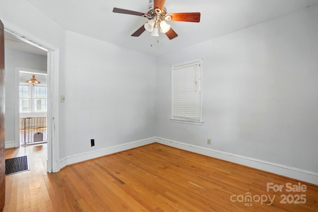 spare room featuring light wood finished floors, visible vents, baseboards, and ceiling fan
