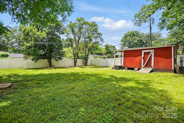 view of yard featuring an outdoor structure, a fenced backyard, and a storage unit