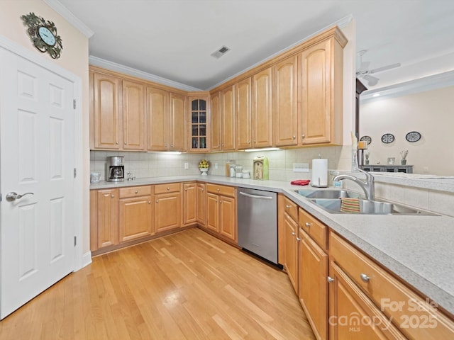 kitchen with light wood-style flooring, a sink, stainless steel dishwasher, visible vents, and decorative backsplash
