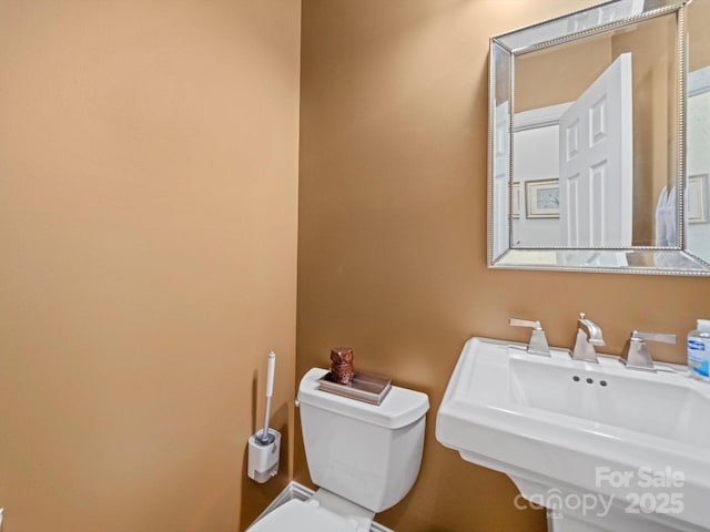 half bathroom featuring a sink and toilet