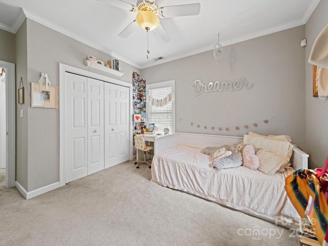 carpeted bedroom with crown molding, a closet, a ceiling fan, and visible vents