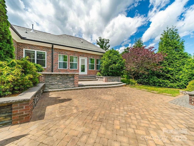 back of property with a patio area and brick siding
