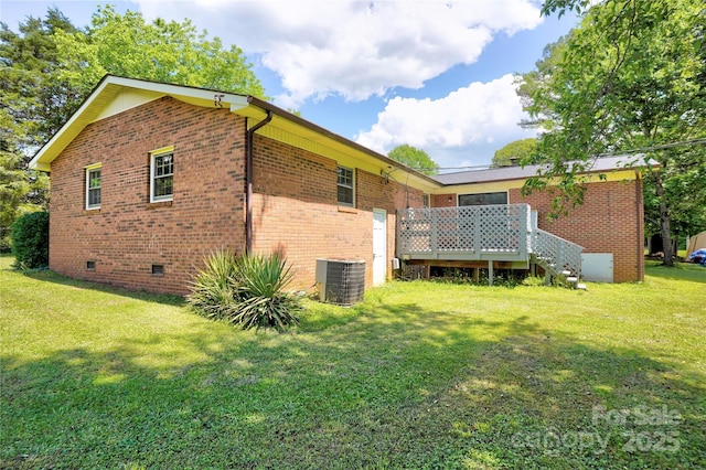 back of property featuring central AC, crawl space, brick siding, a yard, and a deck