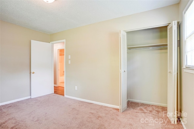 unfurnished bedroom featuring carpet flooring, multiple windows, and a closet