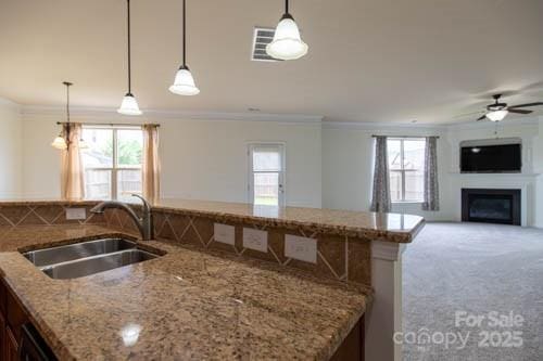 159 Saye Pl, Mooresville, NC 28115 - kitchen with ornamental molding, open floor plan, a ceiling fan, a fireplace, and pendant lighting