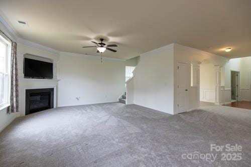 159 Saye Pl, Mooresville, NC 28115 - unfurnished living room featuring a ceiling fan, carpet flooring, stairway, a glass covered fireplace, and crown molding