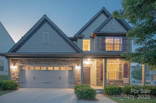 159 Saye Pl, Mooresville, NC 28115 - craftsman-style home with a garage, covered porch, driveway, and stone siding