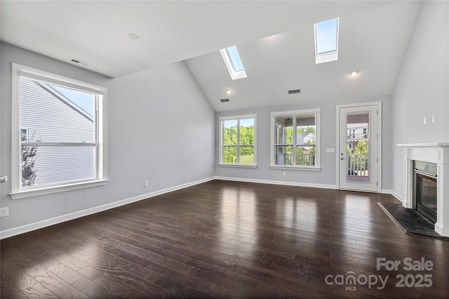 unfurnished living room with lofted ceiling, a skylight, a premium fireplace, dark wood-style flooring, and baseboards