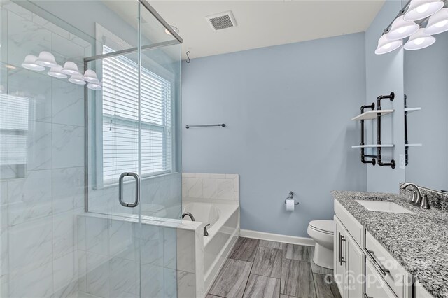 bathroom with toilet, vanity, a bath, a stall shower, and baseboards