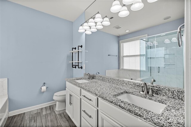 full bathroom featuring a shower stall, toilet, baseboards, a tub to relax in, and a chandelier