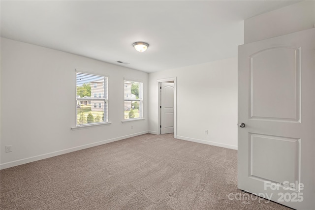 unfurnished bedroom with light colored carpet and baseboards