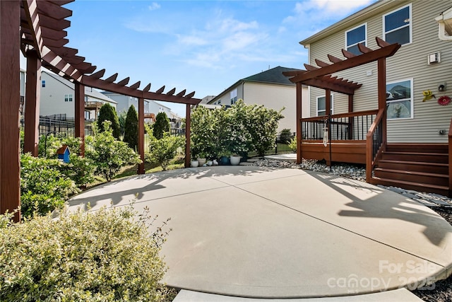 view of patio with a pergola, fence, and a deck