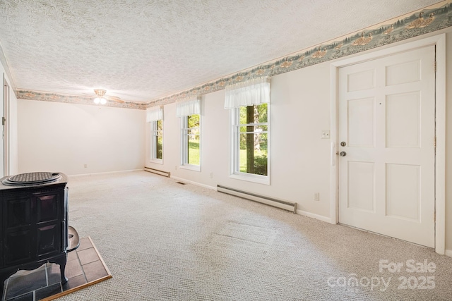 3127 Butler Bridge Rd, Mills River, NC 28759 - unfurnished living room featuring a baseboard heating unit, a textured ceiling, carpet floors, a wood stove, and baseboards