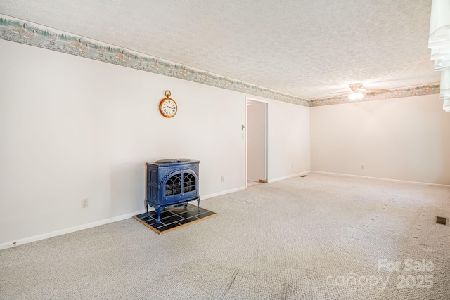3127 Butler Bridge Rd, Mills River, NC 28759 - unfurnished living room featuring a wood stove, ceiling fan, carpet floors, a textured ceiling, and baseboards