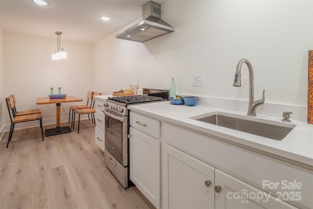 47 Lakeview Rd, Asheville, NC 28804 - kitchen featuring stainless steel range with gas cooktop, wall chimney exhaust hood, a sink, white cabinets, and light wood finished floors