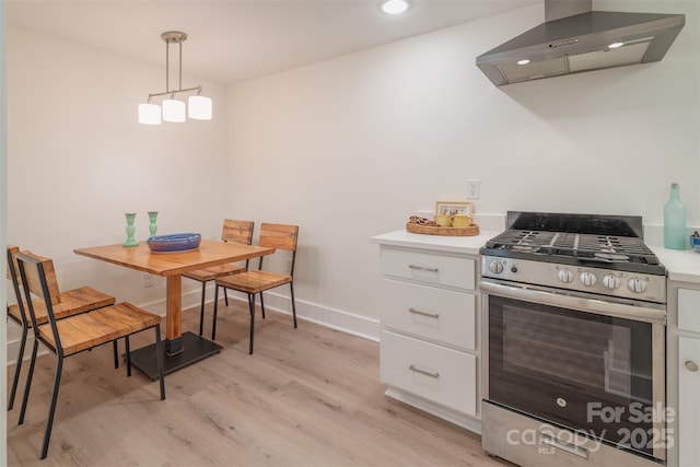 47 Lakeview Rd, Asheville, NC 28804 - kitchen with stainless steel gas range oven, wall chimney exhaust hood, white cabinetry, light wood finished floors, and light countertops