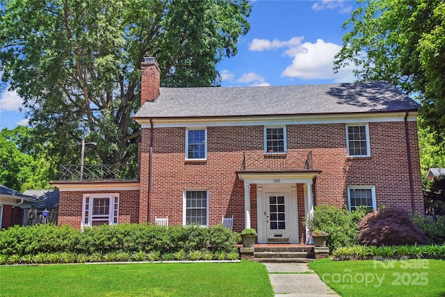 1101 Pee Dee Ave, Albemarle, NC 28001 - georgian-style home with a chimney, brick siding, a front yard, and a shingled roof