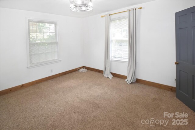 1101 Pee Dee Ave, Albemarle, NC 28001 - carpeted empty room with plenty of natural light, baseboards, and a chandelier