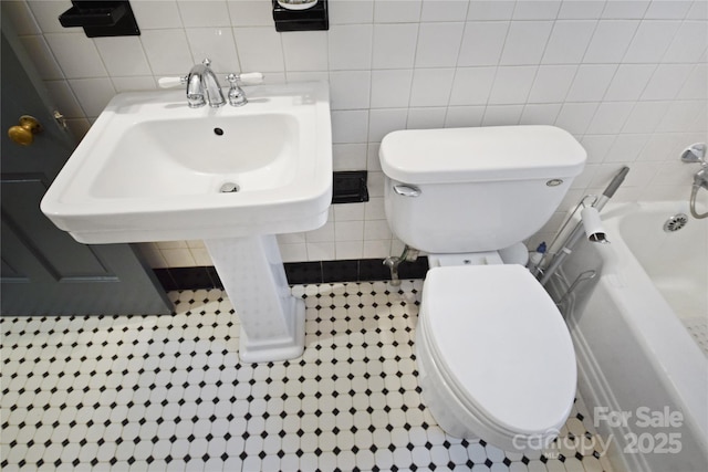 1101 Pee Dee Ave, Albemarle, NC 28001 - bathroom with toilet, tile walls, a tub to relax in, and tile patterned floors