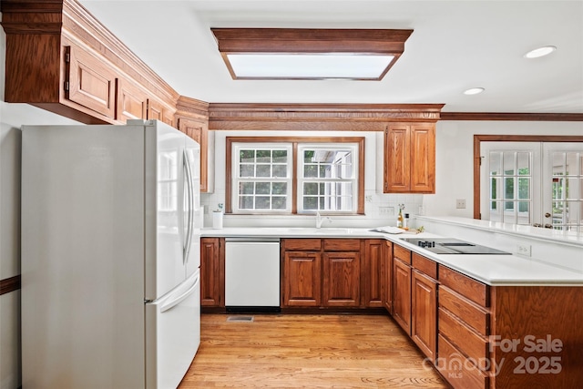7103 Forest Ridge Rd, Matthews, NC 28104 - kitchen featuring white appliances, healthy amount of natural light, light wood finished floors, a sink, and crown molding