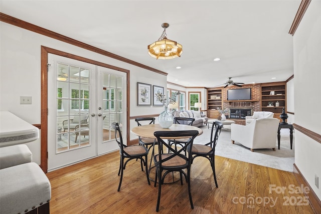 7103 Forest Ridge Rd, Matthews, NC 28104 - dining space featuring baseboards, a fireplace, a ceiling fan, light wood-style flooring, and ornamental molding