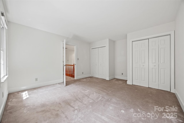 7103 Forest Ridge Rd, Matthews, NC 28104 - unfurnished bedroom with two closets, carpet floors, and baseboards