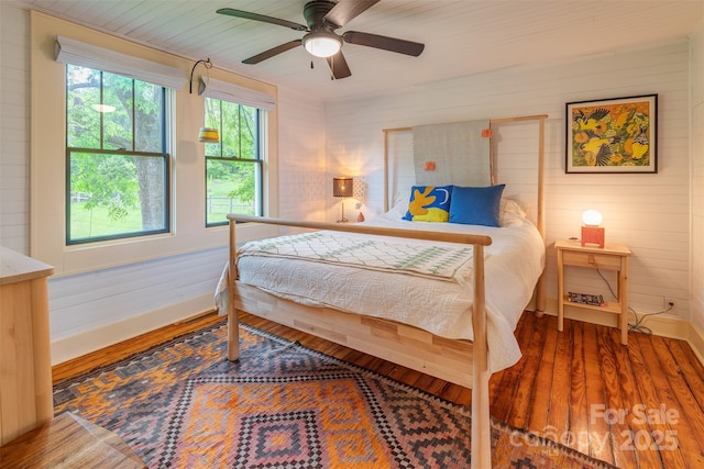 564 Jupiter Rd, Weaverville, NC 28787 - bedroom featuring baseboards, wood finished floors, wooden walls, and ceiling fan