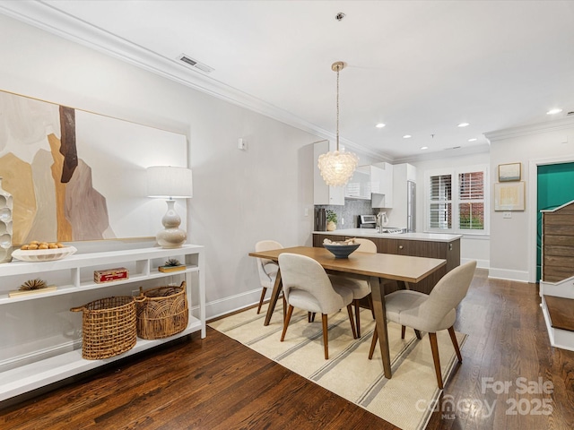 dining room featuring crown molding, baseboards, wood finished floors, recessed lighting, and a chandelier